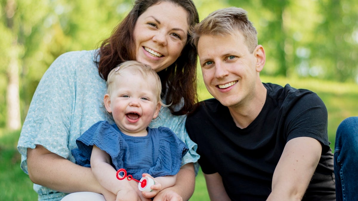 a man and woman holding a baby